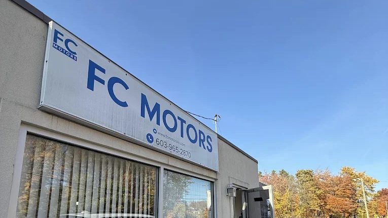 The FC Motors sign and storefront on Candia Road in Manchester, NH, a dealership that buys used cars for cash