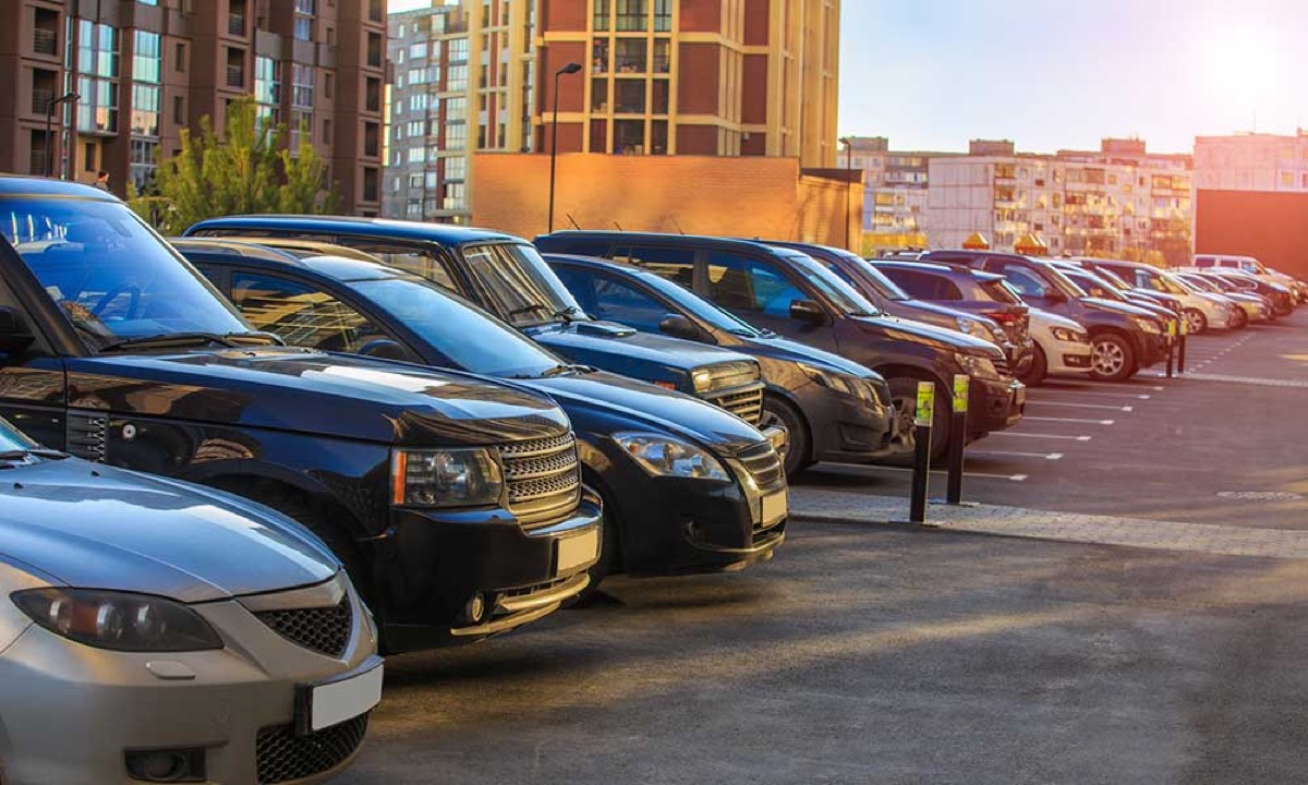 A row of used SUVs and sedans parked side by side in a sunlit parking lot